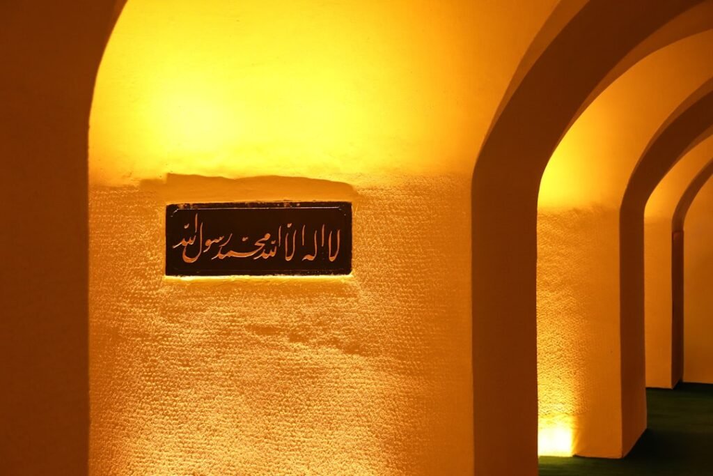 Galerie voûtée éclairée, avec une plaque portant une inscription en arabe