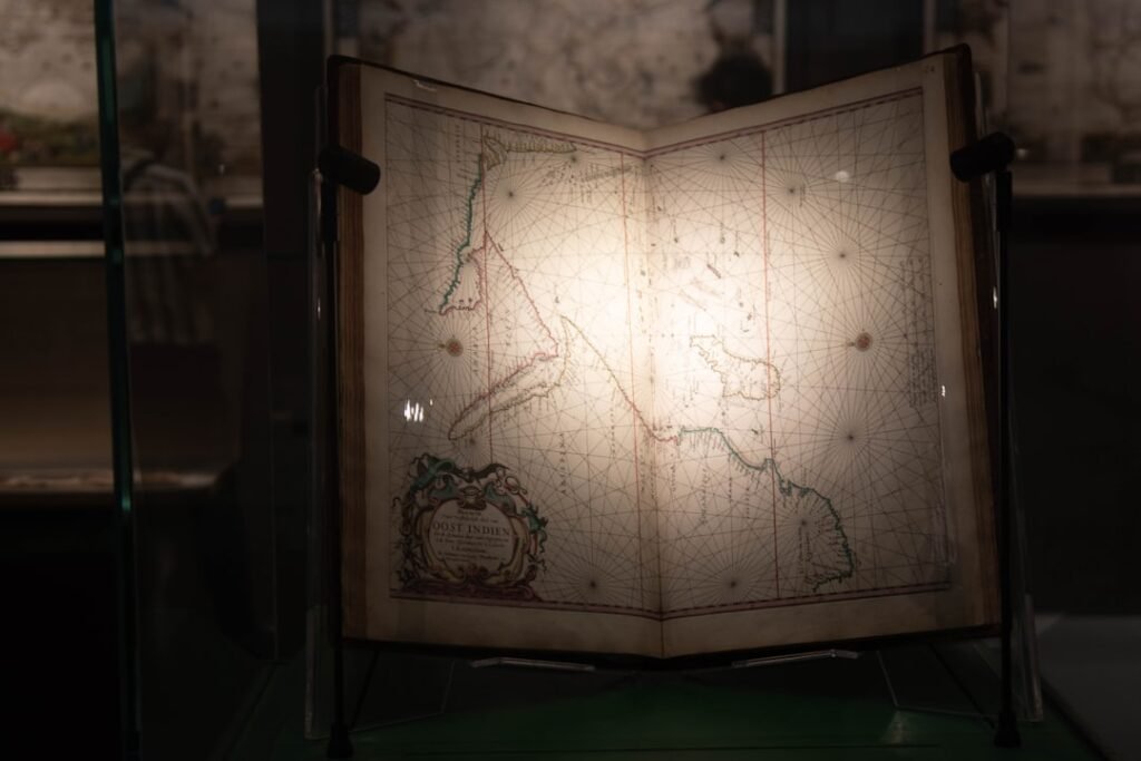 Atlas ancien ouvert sur une carte, exposé en vitrine