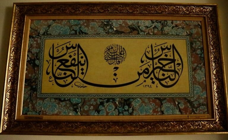 Calligraphie arabe à l’encre noire sur fond doré, dans un cadre ouvragé